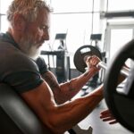 Man in his 60's lifting weights in the gym