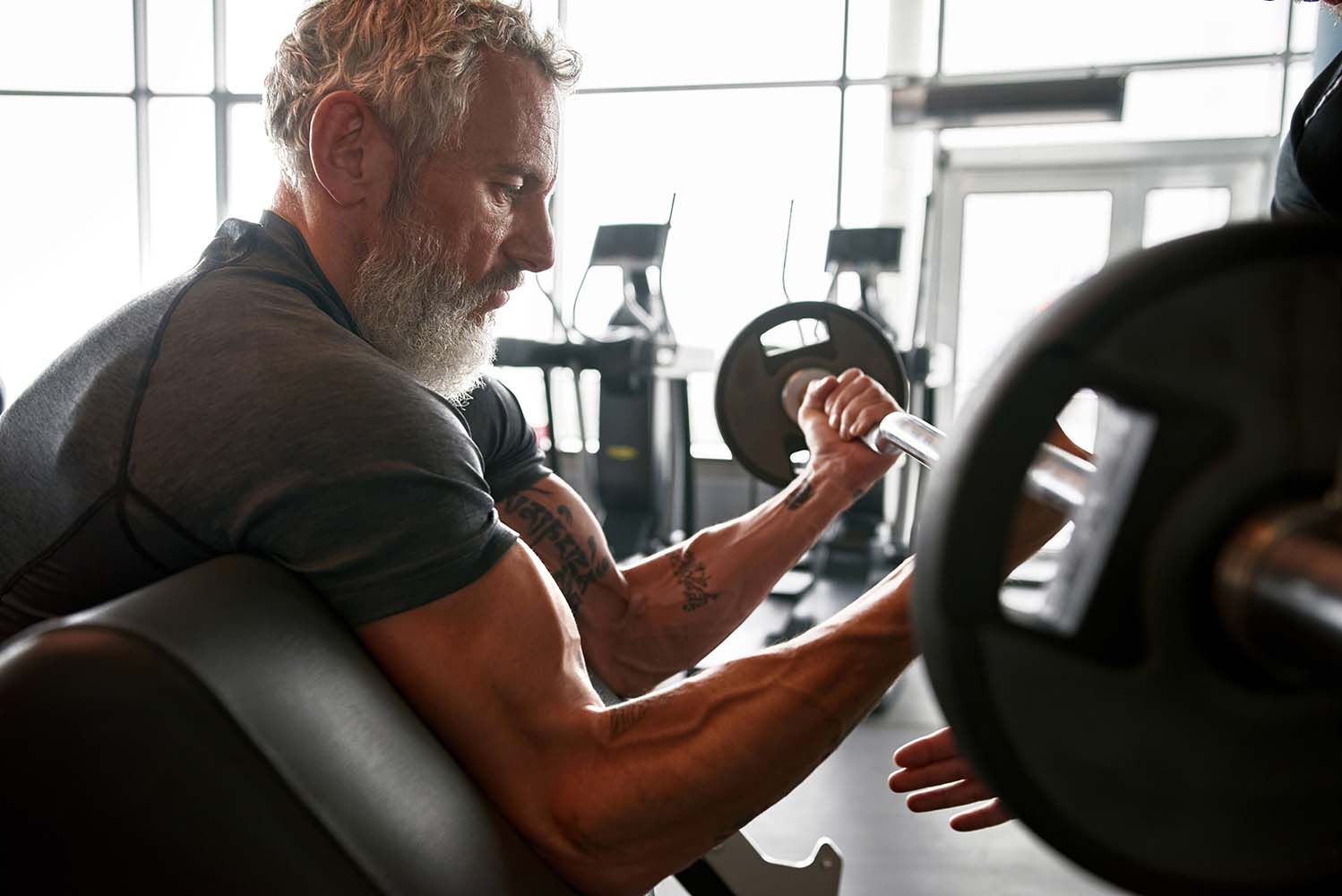 Man in his 60's lifting weights in the gym
