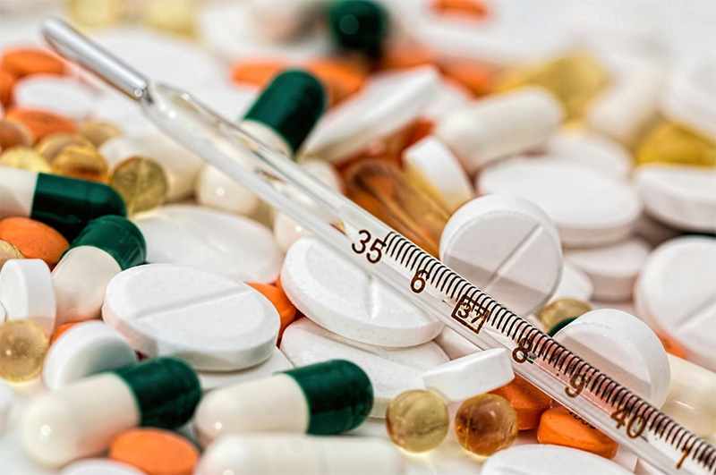 Various pills and a thermometer