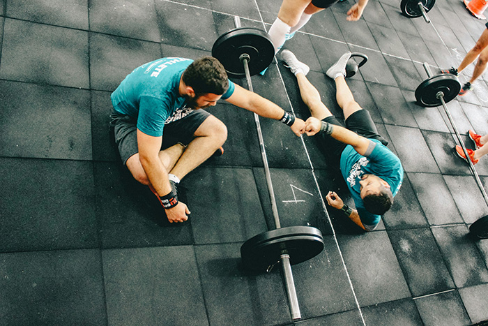 Two men in a gym giving each other a fist bump