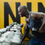 Man lifting a dumbbell weight in a gym