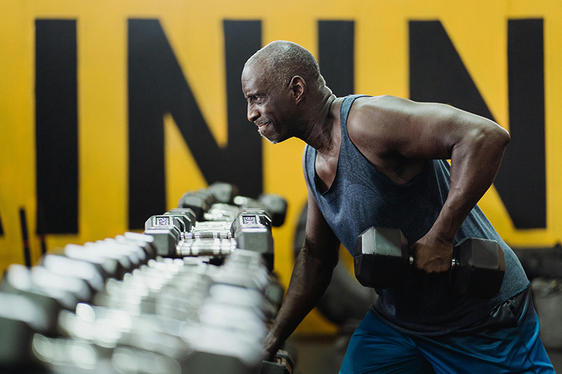 Man lifting a dumbbell weight in a gym